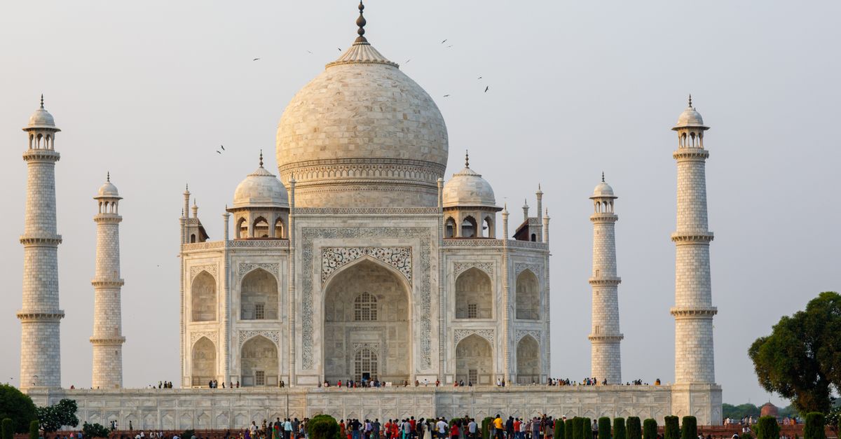 Captivating image of the Taj Mahal, a UNESCO World Heritage site, with tourists enjoying the view.